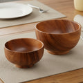 Two small wooden bowls with a rich brown wood grain pattern, shown on a clean white background.