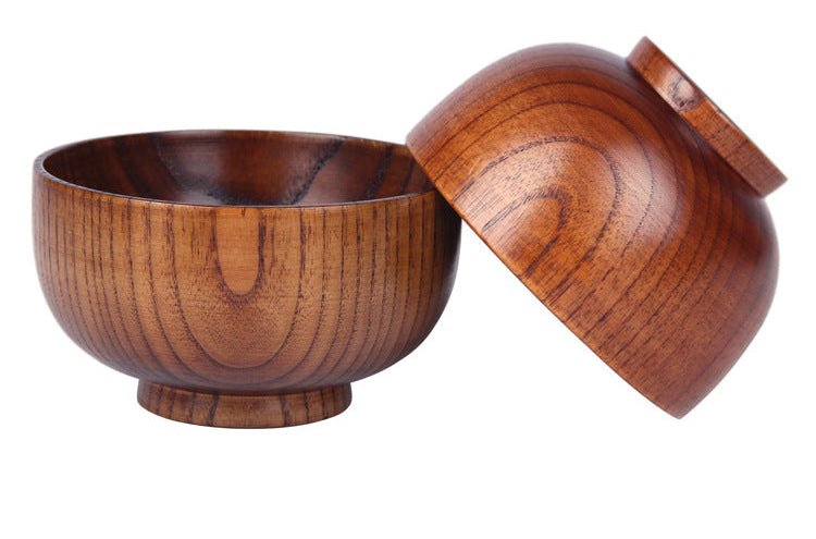 A wooden bowl with its lid leaning against it on a white background, featuring a visible grain pattern and a small logo in the top-left corner.